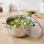 Load image into Gallery viewer, Stainless steel pot with glass lid cooking steaming green spinach curry with paneer cubes on wooden kitchen counter