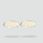 Load image into Gallery viewer, Two round silver idli steamers each with seven uncooked idli batter discs on a light gray background