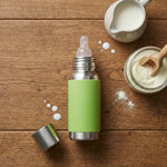 Load image into Gallery viewer, Stainless steel baby bottle with green sleeve, milk jug, and powdered formula on wooden surface