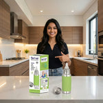 Load image into Gallery viewer, Smiling woman in modern kitchen pointing at Max Fresh stainless steel baby feeding bottle with green cover