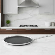 Honeycomb pattern dosa tawa pan with stainless steel handle on marble kitchen countertop