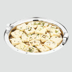 Load image into Gallery viewer, Steamed Indian snack dhokla pieces garnished with mustard seeds and herbs in a round stainless steel tray