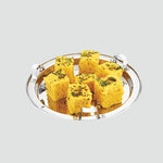 Load image into Gallery viewer, Silver stainless steel plate with seven pieces of yellow Indian dhokla garnished with mustard seeds and herbs