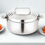 Load image into Gallery viewer, Stainless steel cooking pot with lid and handles on a white surface, plates with food on sides