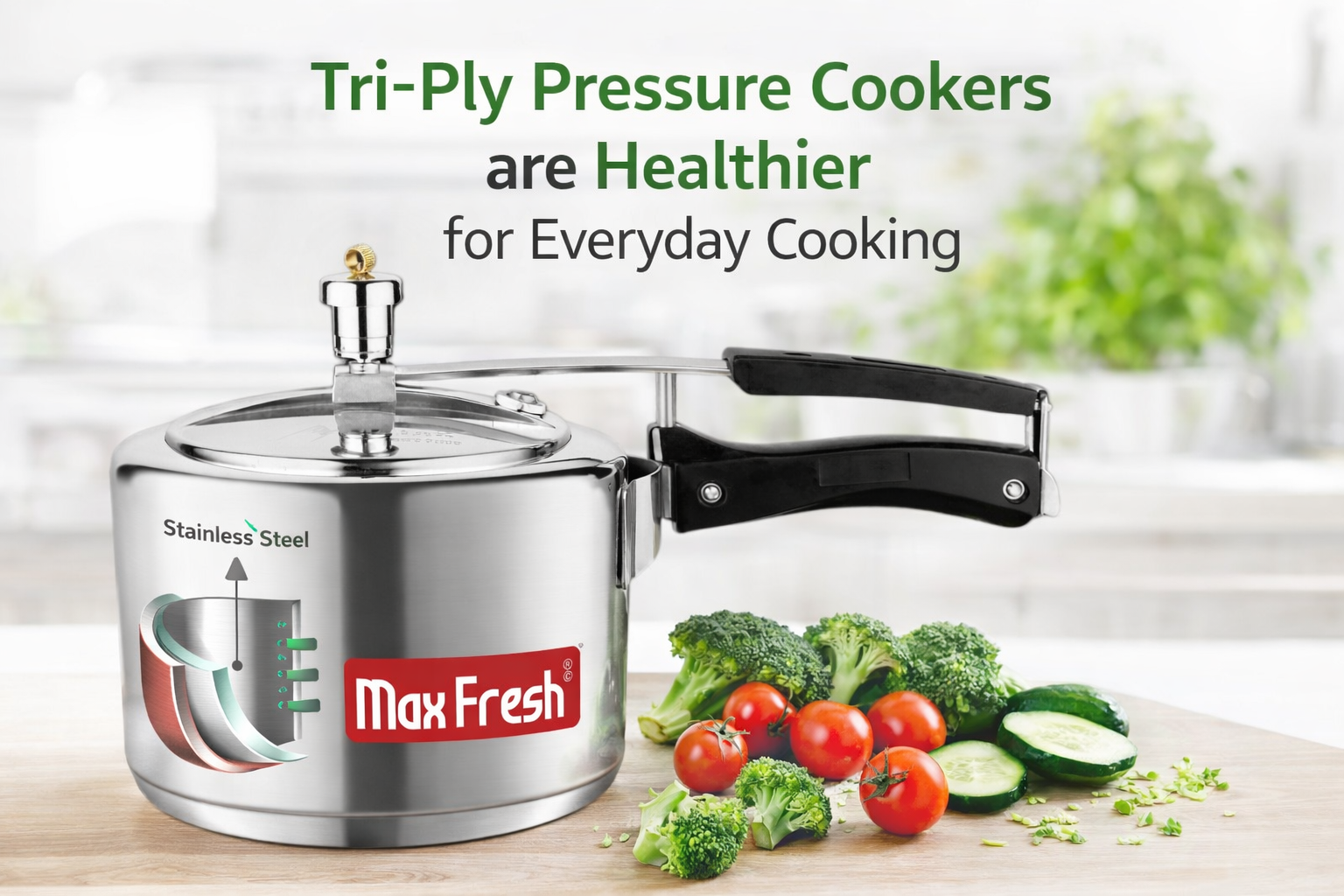 Stainless steel tri-ply pressure cooker with black handle and fresh vegetables on kitchen counter