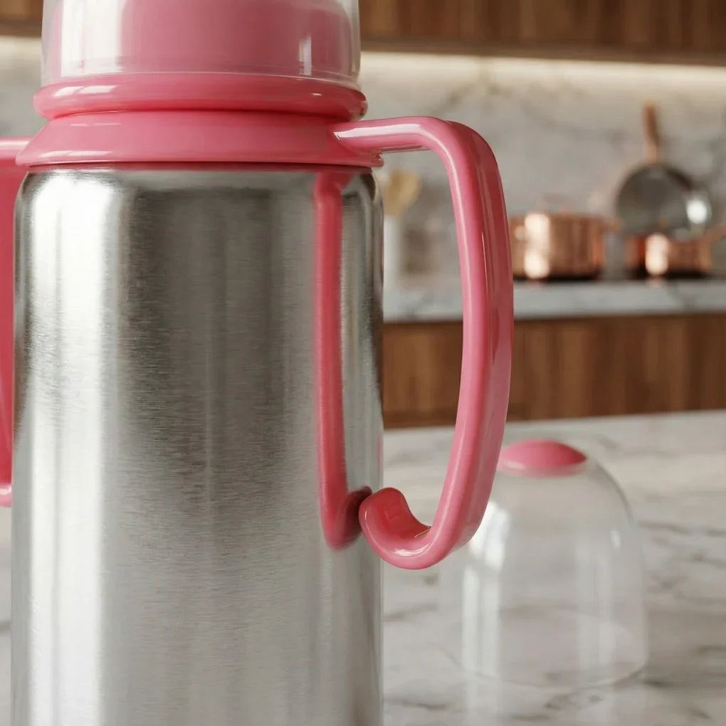 Close-up of stainless steel thermos with pink plastic handle and lid on marble kitchen counter