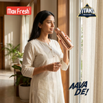Woman holding a stainless steel copper water bottle by a window in a bright home setting