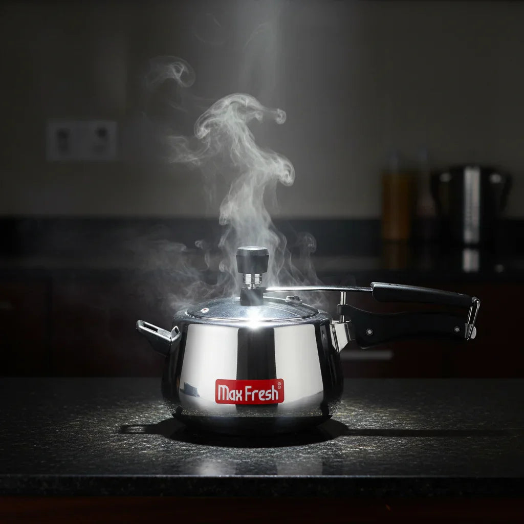 Stainless steel pressure cooker releasing steam on kitchen countertop