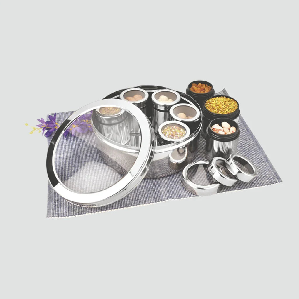 Stainless steel spice box with transparent lid and multiple containers on placemat