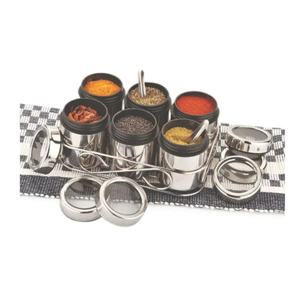 Stainless steel spice jars set with clear lids, arranged on a checkered mat, filled with assorted spices.