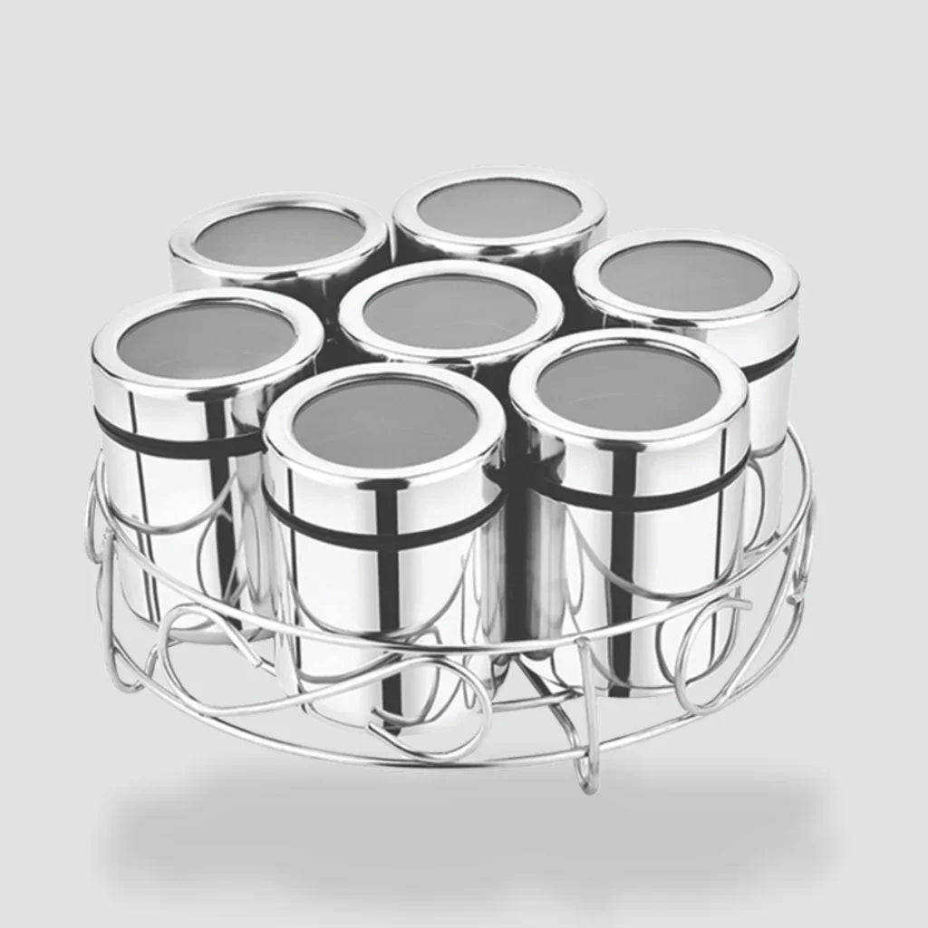 Set of stainless steel glasses in a round metal holder, kitchenware on plain background