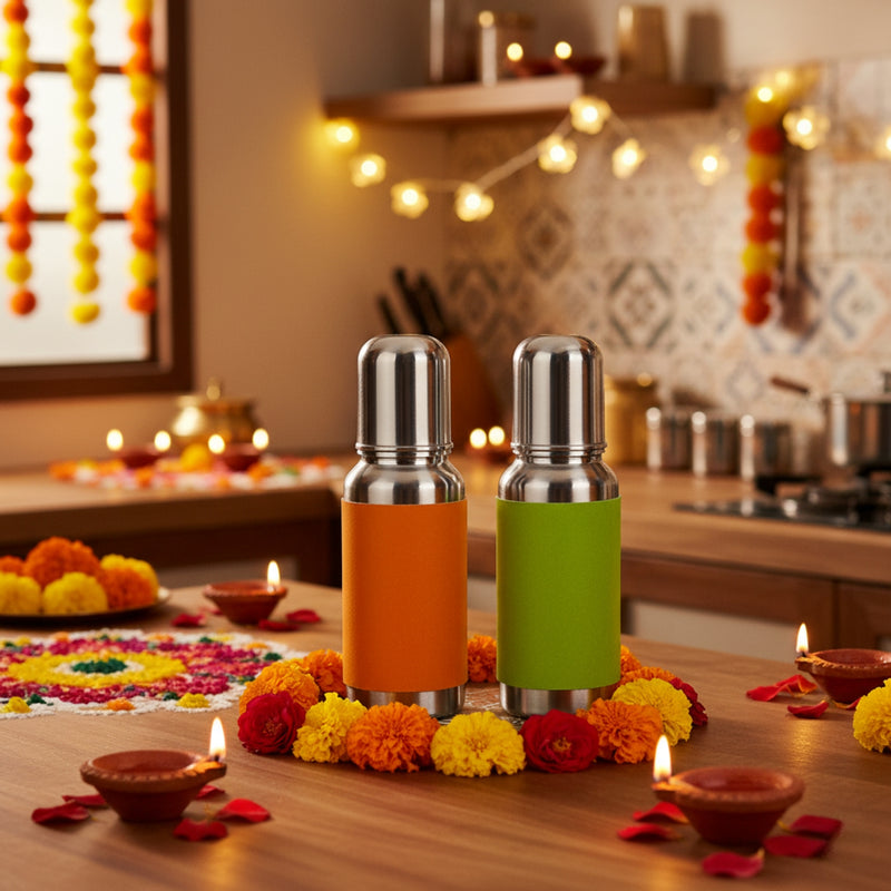 Two spice grinders on a festive table with flowers and candles, set against a decorated room.