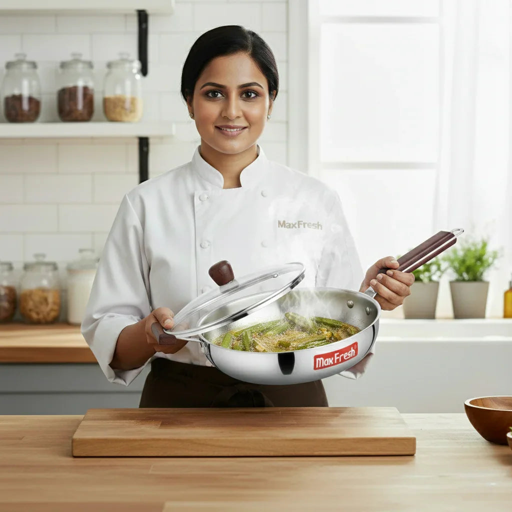 Chef in kitchen holding stainless steel frypan with lid, cooking vegetables, visible MaxFresh logo