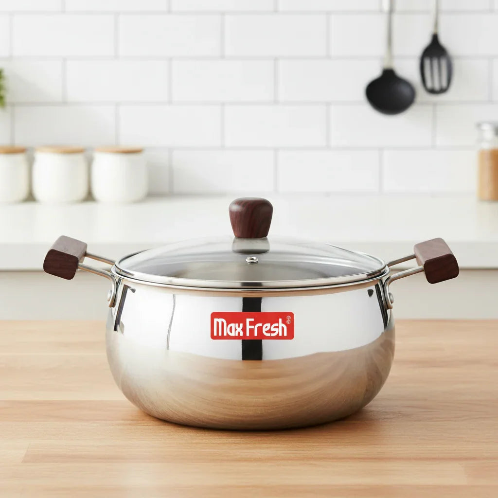 Stainless steel casserole with glass lid and wooden handles on a kitchen countertop
