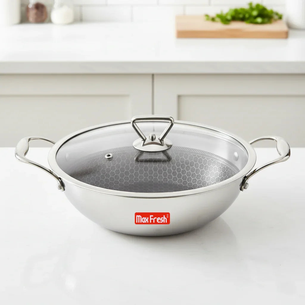 Stainless steel multi kadai with honeycomb non-stick base and glass lid on kitchen counter