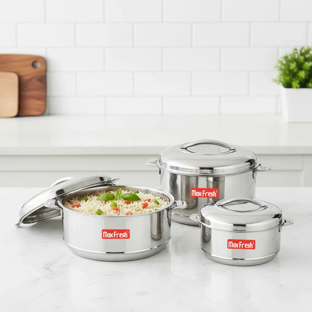 Set of three stainless steel casseroles with lids, one filled with rice, on a kitchen counter