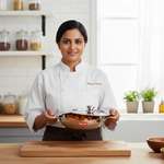 Chef holding stainless steel kadai with steel lid filled with cooked food in a kitchen.
