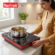 Woman cooking vegetables in a stainless steel casserole on a red induction cooktop in a modern kitchen