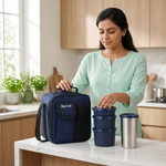 Woman in kitchen packing blue lunch bag with stainless steel casserole containers and tumbler