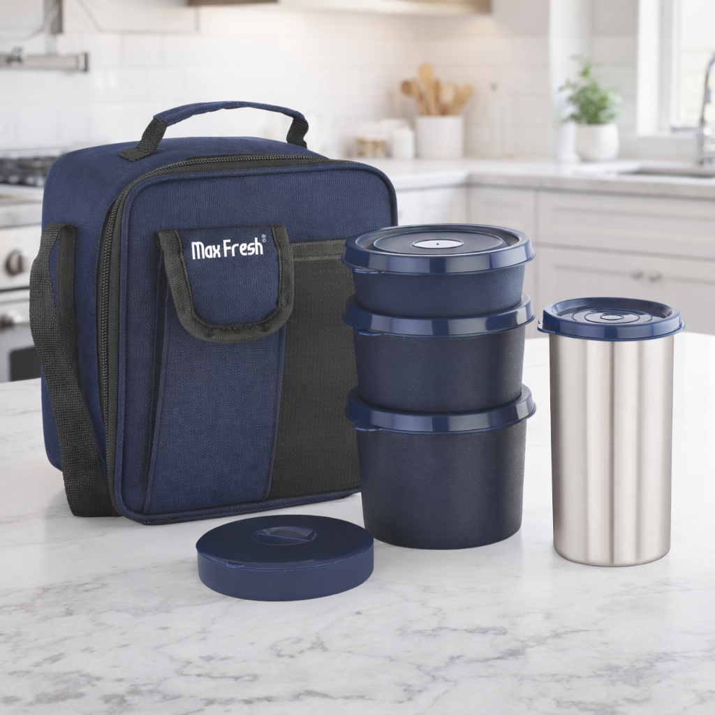 Lunch box set with blue insulated bag, three food containers, and stainless steel tumbler on kitchen counter