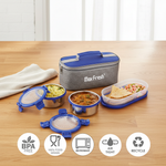Stainless steel lunch box set with blue lids, insulated lunch bag, food containers and BPA free, microwave safe, airtight features icons on wooden table.