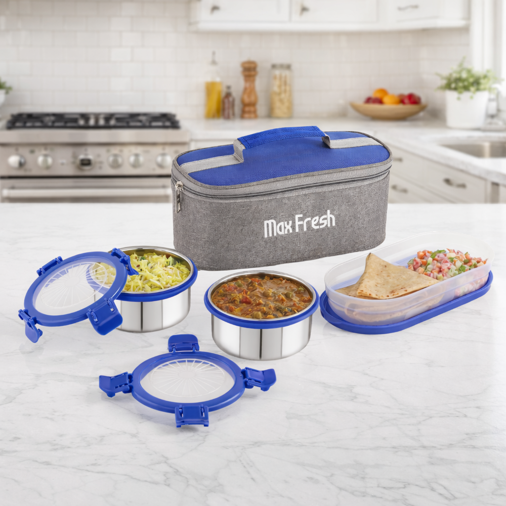 Stainless steel lunch containers with blue lids and an insulated carry bag in a modern kitchen