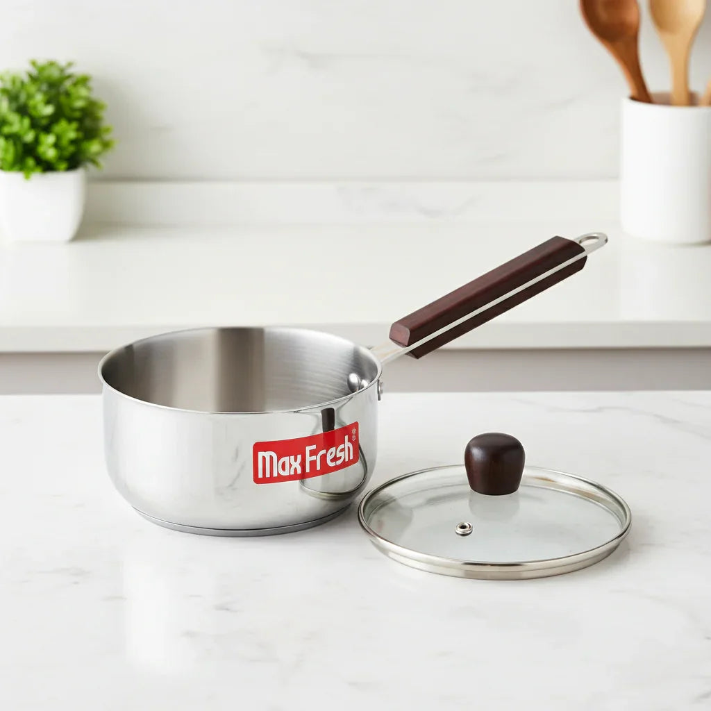 Stainless steel saucepan with wooden handle and glass lid on kitchen counter