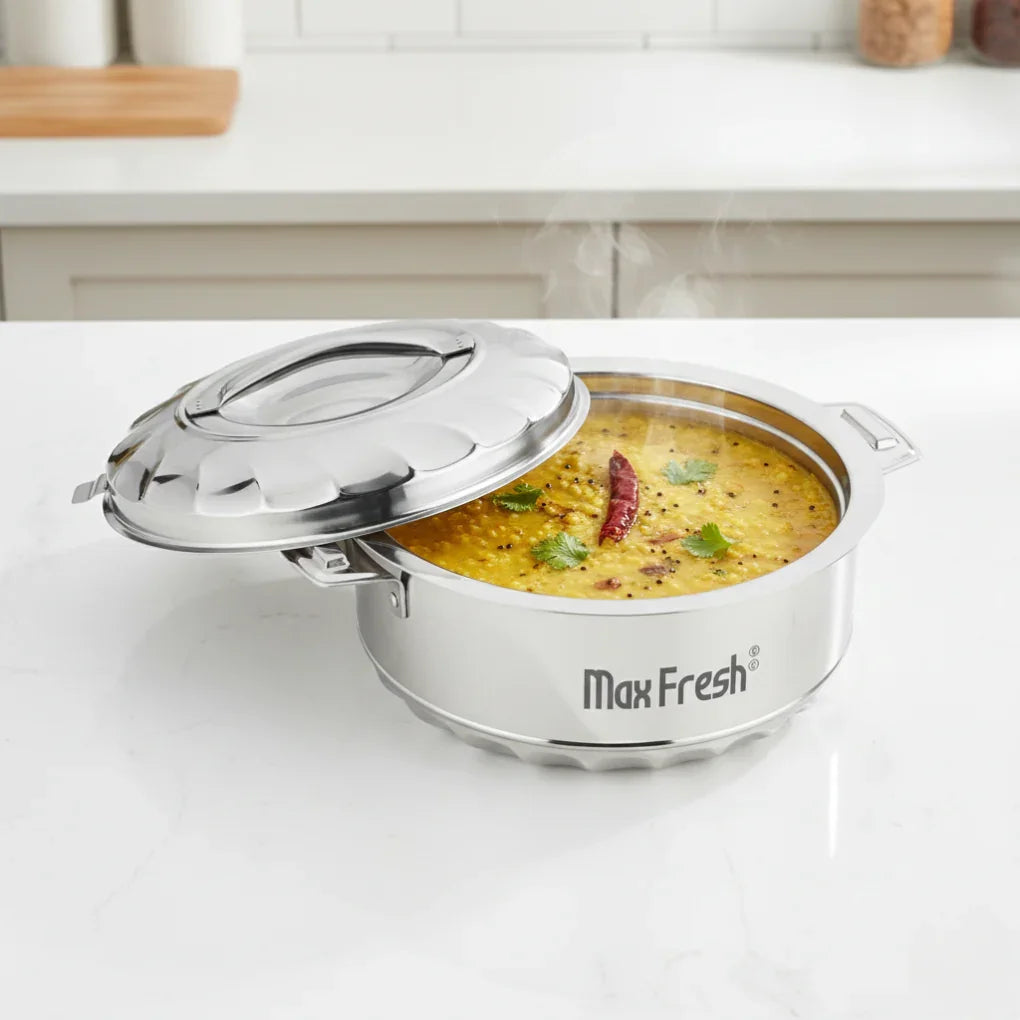Stainless steel casserole with lid, hot dal dish inside, on a modern kitchen countertop