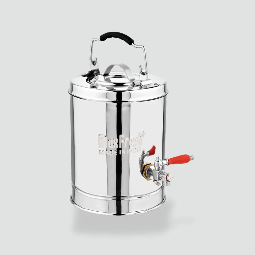 Stainless steel tea dispenser jar with lid, handle, and red tap on light background