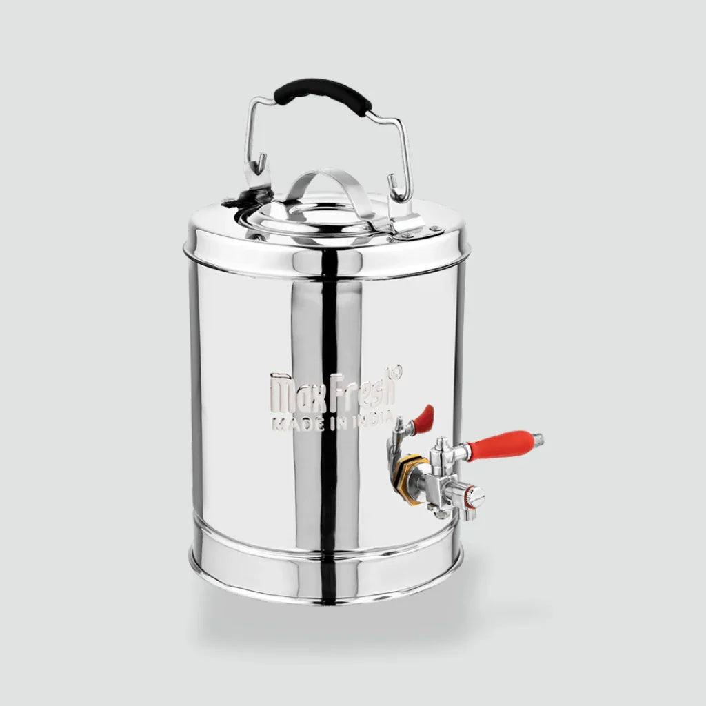 Stainless steel tea dispenser with lid, handle, and red tap on light background
