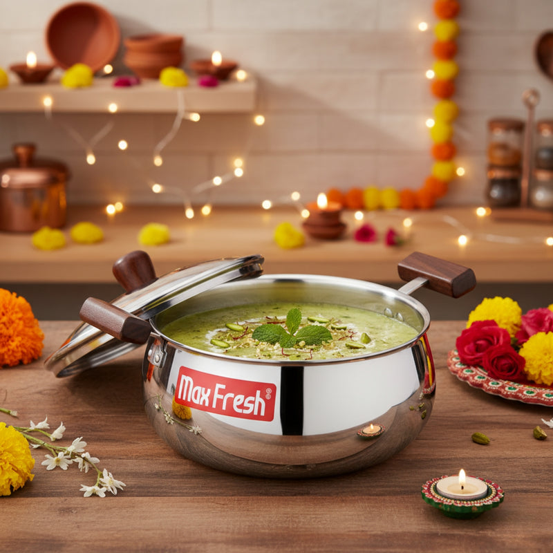 Stainless steel pot with a lid on a wooden table, decorated with flowers and lights.