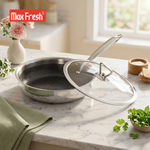 Stainless steel frying pan with glass lid on a marble countertop, Max Fresh brand visible