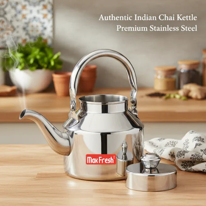 Shiny stainless steel Indian chai kettle with lid on wooden kitchen countertop