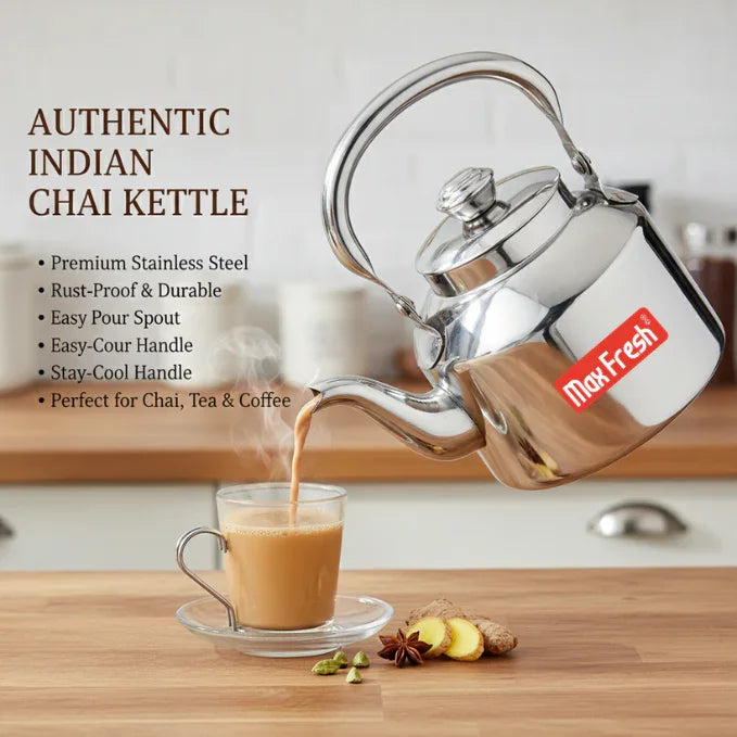 Stainless steel Indian chai kettle pouring hot tea into a glass cup on kitchen counter.