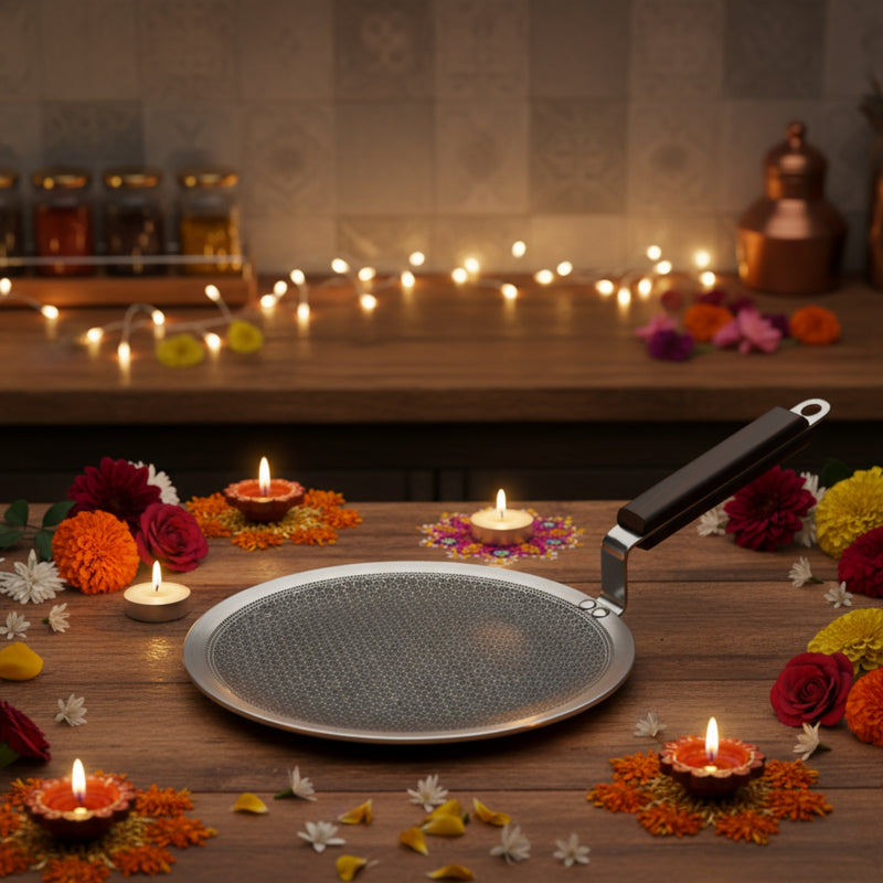 Metallic pan on a wooden surface with candles and flowers, set against a warm, blurred background.