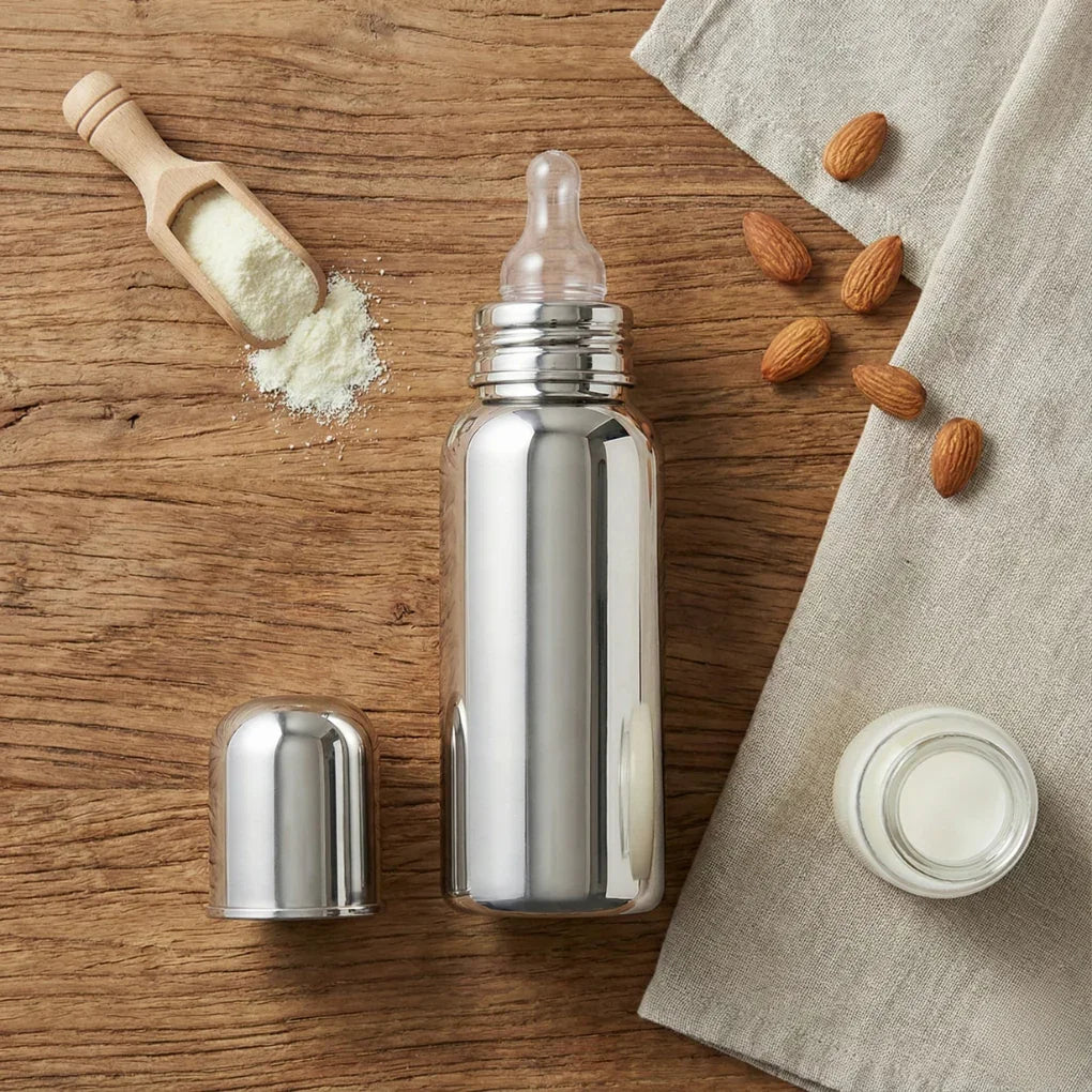 Stainless steel baby feeding bottle with cap, powdered milk and almonds on wooden table