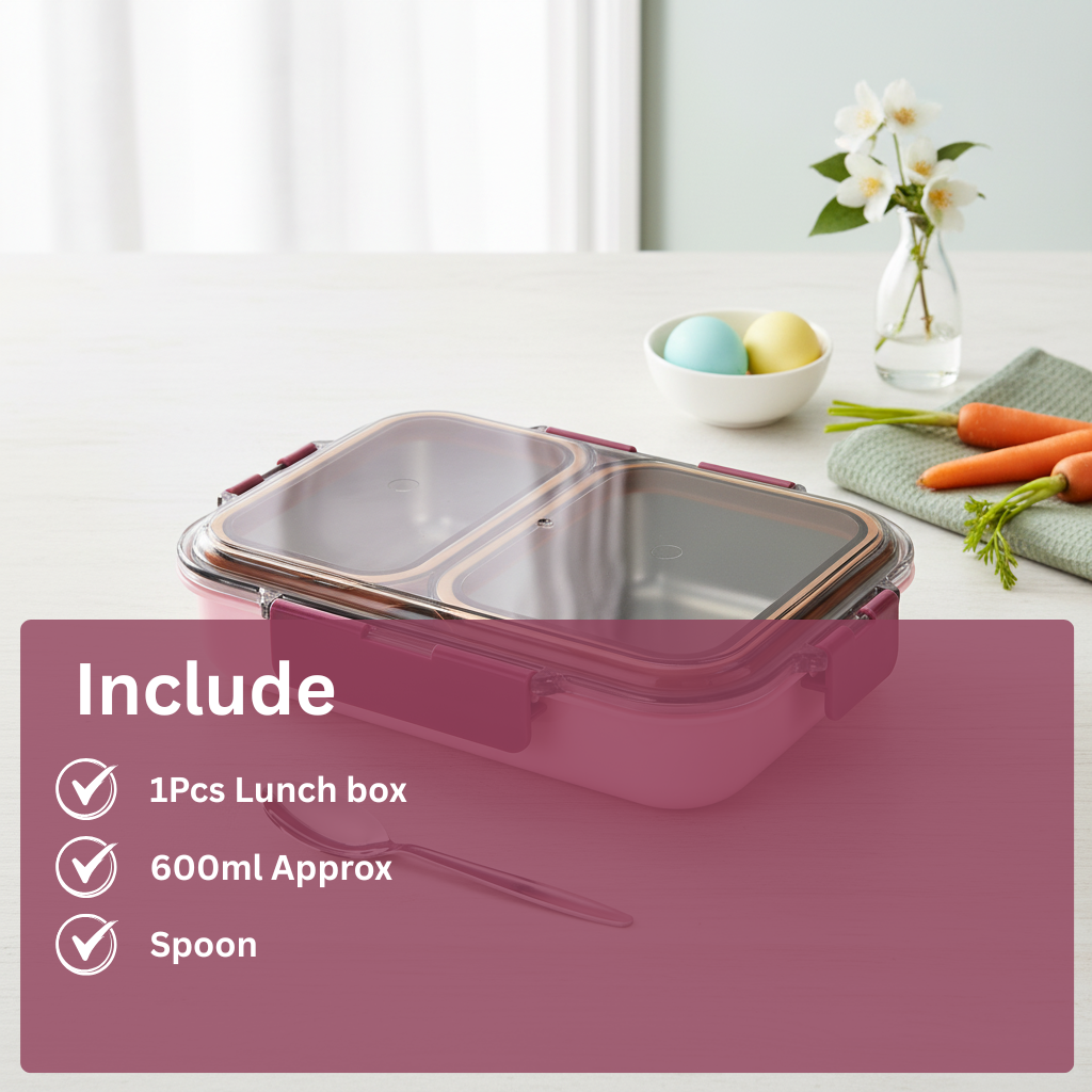 Pink divided lunch box with transparent lid, spoon, and fresh vegetables on a kitchen table
