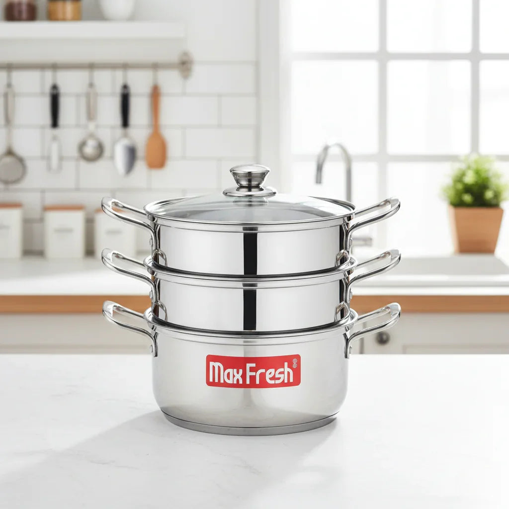 Three-tier stainless steel steamer with glass lid on a kitchen counter.