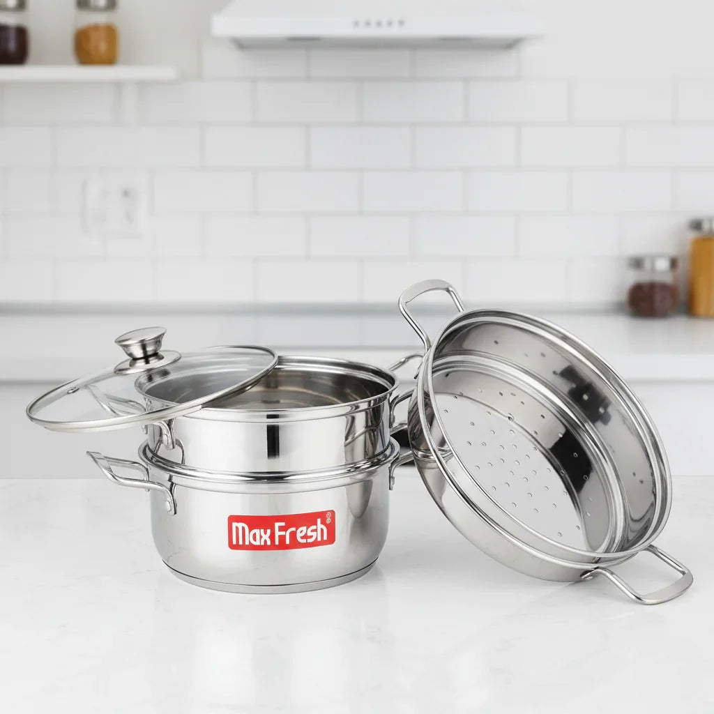 Three-tier stainless steel steamer set with glass lid on a kitchen counter