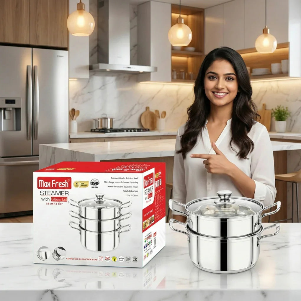 Smiling woman in modern kitchen pointing at Max Fresh stainless steel 3-tier steamer with glass lid