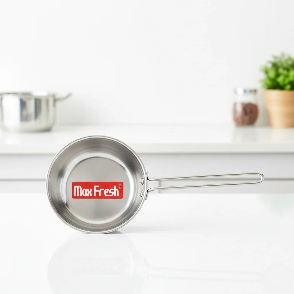 Stainless steel saucepan with long handle on a white kitchen counter, Max Fresh logo visible inside.